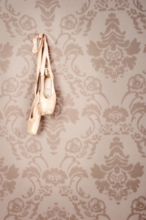 pair of old ballet shoes hanging on a wallの写真素材
