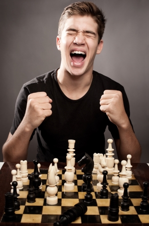 happy young man celebrating chess winの写真素材