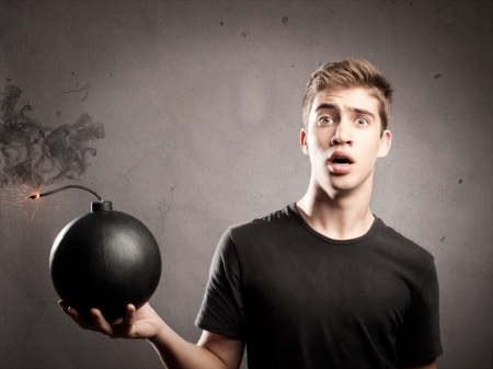 scared young man holding an old-fashioned bombの写真素材