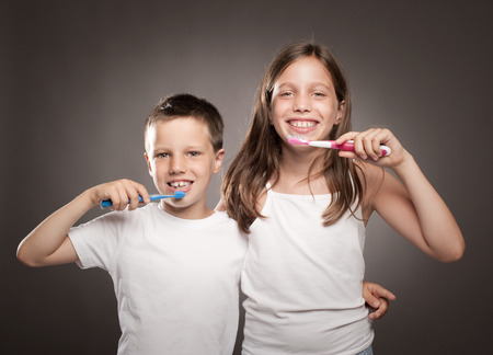 children brushing her teeth on a gray backgroundの写真素材