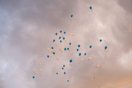 balloons in a cloudy sky at sunsetの写真素材
