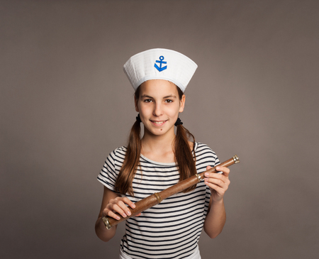 little marine holding a spyglass on a gray backgroundの写真素材