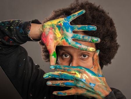 black woman with her hands painted on a gray backgroundの写真素材