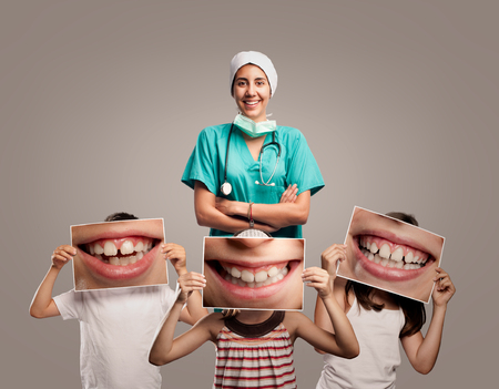 dentist doctor with children holding a picture of a mouth smilingの写真素材