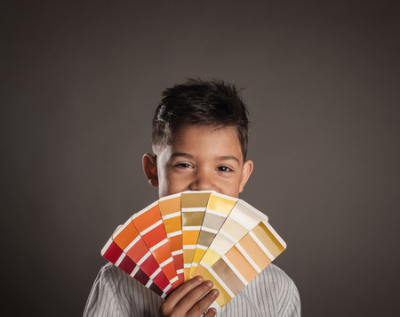 kid holding a palette on a gray backgroundの写真素材
