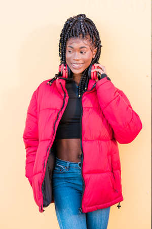 Beautiful African woman outdoors. Black woman listening to music with headphonesの写真素材