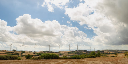 panorama of wind turbines farm field on a cloudy day