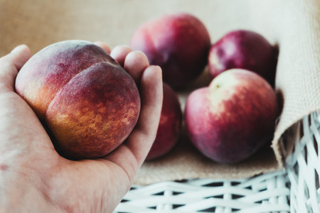 Closeup picking a peach from a white wooden boxの写真素材