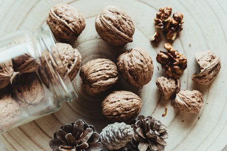 Top view of walnuts and tree pineapples on a rustic wooden table.の写真素材