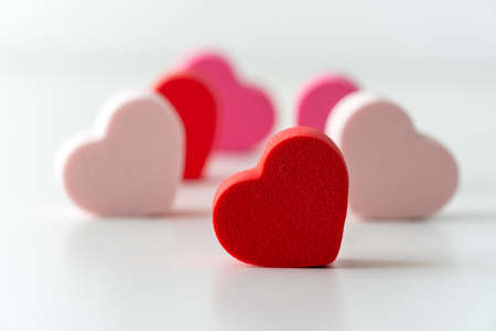 Close-up of red and pink hearts with white background.