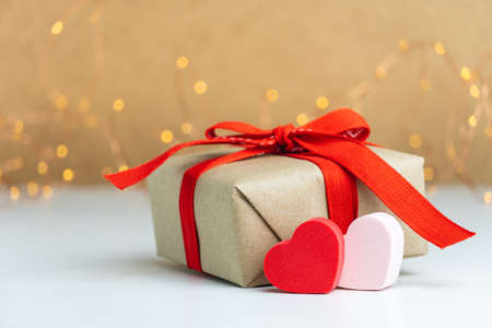 Close-up of gift box with red ribbon and two hearts.の写真素材