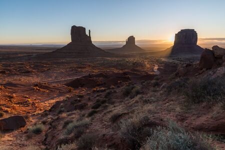 The first sunbeams of the morning lighting up the desert. Monument Valley gets lighted by the morning sunbeamsの写真素材