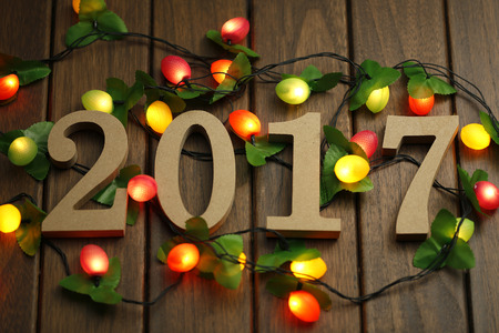 2017 Happy New Year, wooden figures and flashing lights on the retro desktop
