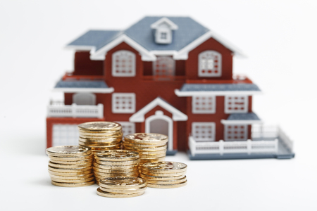RMB coins stacked in front of the housing model (house prices, house buying, real estate, mortgage concept)の写真素材