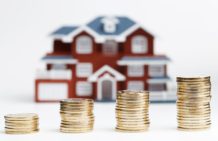 RMB coins stacked in front of the housing model (house prices, house buying, real estate, mortgage...