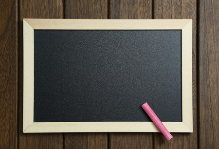 empty blackboard with chalks on vintage wooden backgroundの写真素材