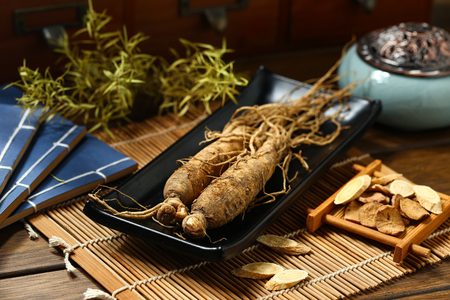 
ginseng in black plate on wooden tableの写真素材