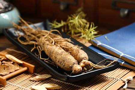 
ginseng in black plate on wooden tableの写真素材
