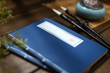 chinese vintage old book,incense burner and brush on wooden tableの写真素材