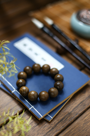 wooden bracelet,incense burner,brush,and vintage old book on wooden tableの写真素材