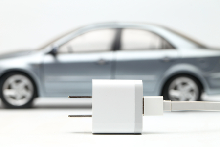 electric car with plug and wire on white backgroundの写真素材