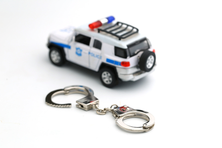 Police car toy and handcuff isolated on white background