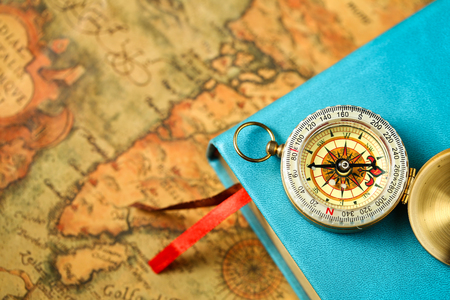 close up view of Compass and book on vintage old map paper backgroundの写真素材