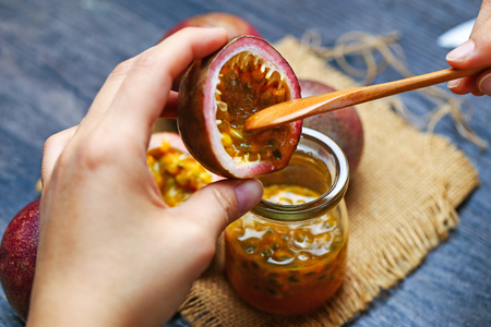 Person extracting passion fruit into glass bottleの写真素材