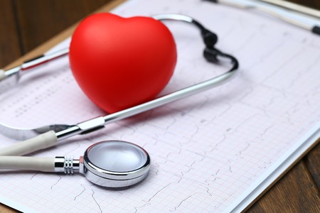 Red heart with stethoscope and electrocardiogram on wooden backgroundの写真素材