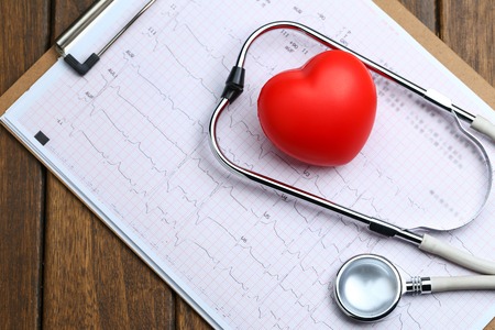 Red heart with stethoscope and electrocardiogram on wooden backgroundの写真素材