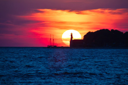 Epic sunset view with lighthouse and saiboat in Zadar, Dalmatia, Croatiaの写真素材
