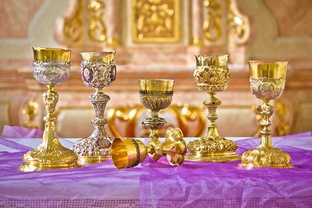 Golden holy grails on church altar view, religious equipmentの写真素材