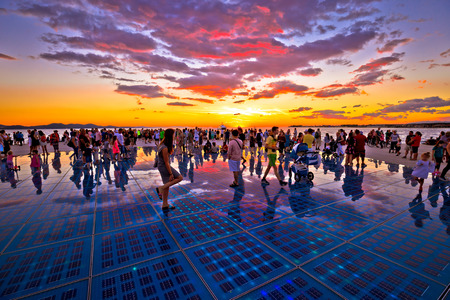 ZADAR, CROATIA - July 18 2017:  Unidentified people in city of Zadar Greetings to the sun landmark in region of Dalmatia, Croatia at colorful sunset. Many tourists visits this solar powered installationon sea coast.のeditorial素材