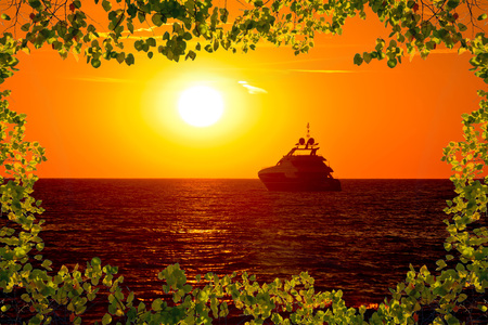 Luxury yacht on open sea at golden sunset view through leaves frame, Zadar, Dalmatia, Croatiaの写真素材
