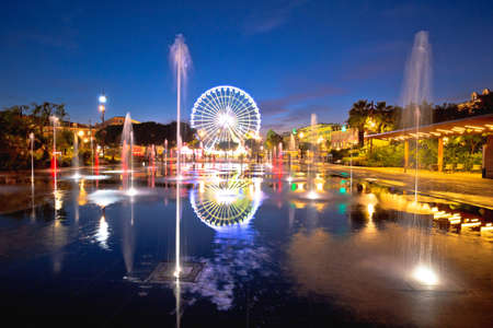 City of Nice ferris wheel and fountain evening mirror view, Alpes-Maritimes region of Franceのeditorial素材