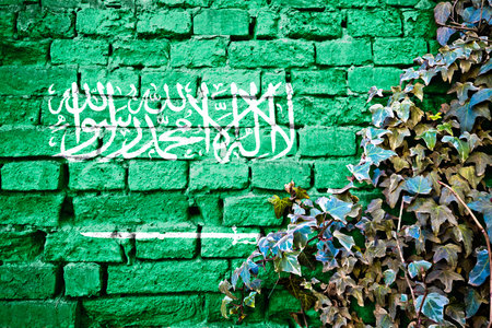 Saudi Arabia grunge flag on brick wall with ivy plant, country symbol conceptの写真素材