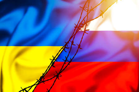 Silk flags of Russian Federation and Ukraine divided by barb wire sun haze illustration, concept of tense relations between Ukraine and Russiaの写真素材