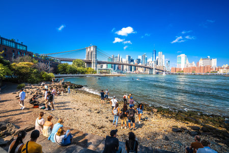 New York City, USA, September 16 2024: New York city East river Pebble Beach in Brooklyn view. People enjoying Manhattan skyline views.の写真素材