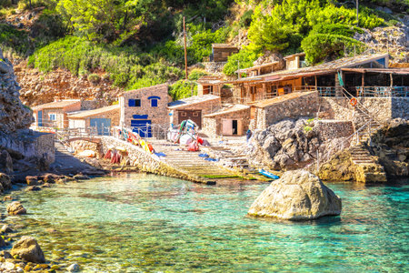 Cala de Deia stone houses and colorful beach in canyon view, Island of Mallorca. Balearic islands of Spain.の写真素材