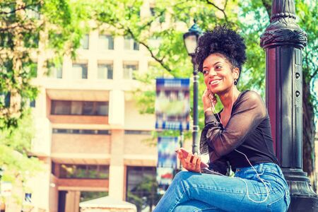 Young African American Woman with afro hairstyle wearing mesh sheer long sleeve shirt blouse, blue...