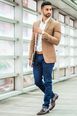 Young Man Business Casual Fashion in New York, with beard, wearing brown blazer, white shirt, blue...