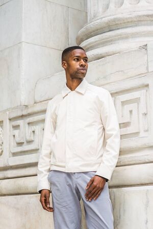 Portrait of Young Handsome African American Man in New York. Young black man wearing light color...