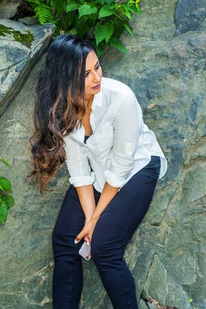 Young East Indian American Woman with long hair traveling, relaxing at Central Park, New York City,...