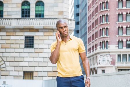 Young African American Man Street Fashion in New York City. Wearing yellow short sleeve shirt, young...