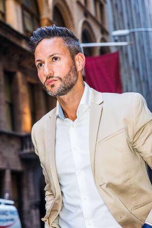 Young handsome European Man with beard traveling in New York City. Young guy wearing beige blaze,...