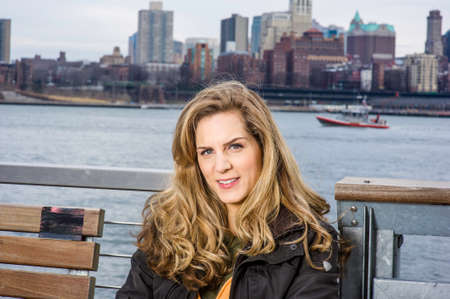 Portrait of Young Woman. The background is a river and big city outline.の写真素材