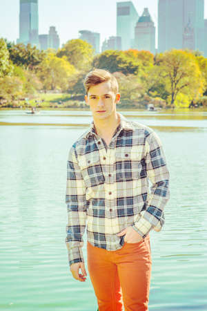 Portrait of Young Man. Dressing in a long sleeve, patterned shirt, red pants, one hand putting in...