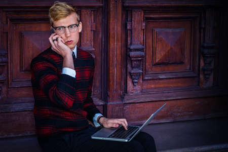 Young Man working in New York City. Young Student wearing patterned red, black knit sweater,...
