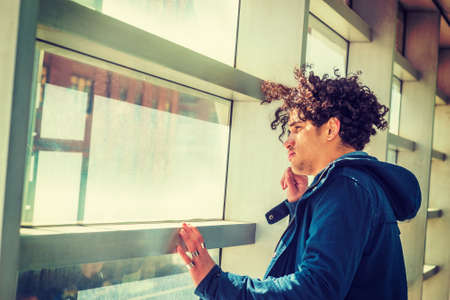 Portrait of American college student in New York. Wearing blue jacket with hood, a guy with freckle...