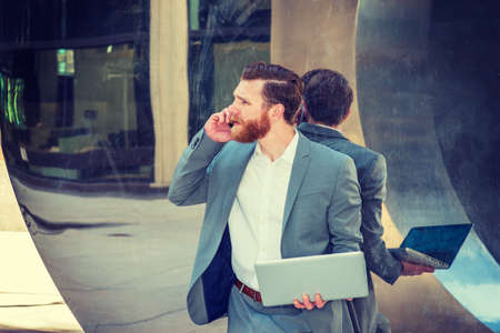 American Businessman with beard, mustache working in New York, wearing cadet blue suit, standing...
